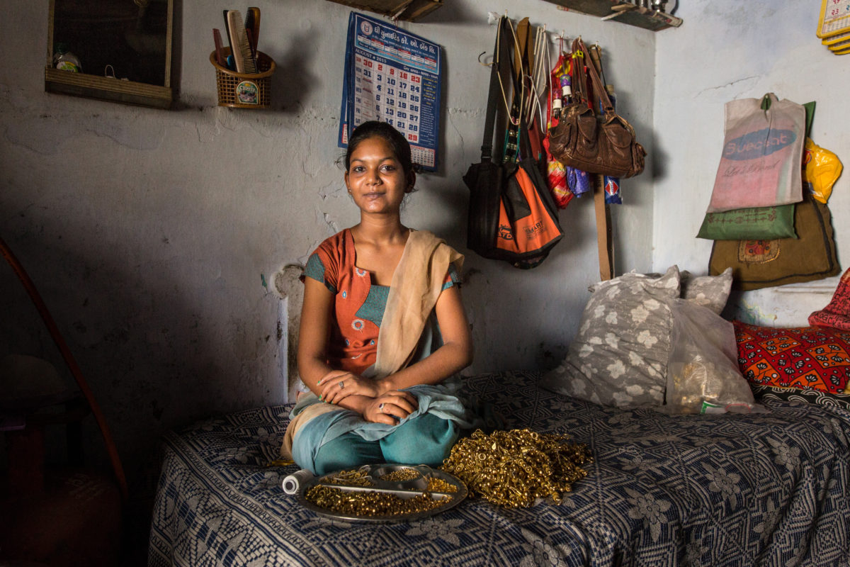 Indian woman sitting alone on her bed.