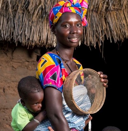 African woman with child and cooking instrument.