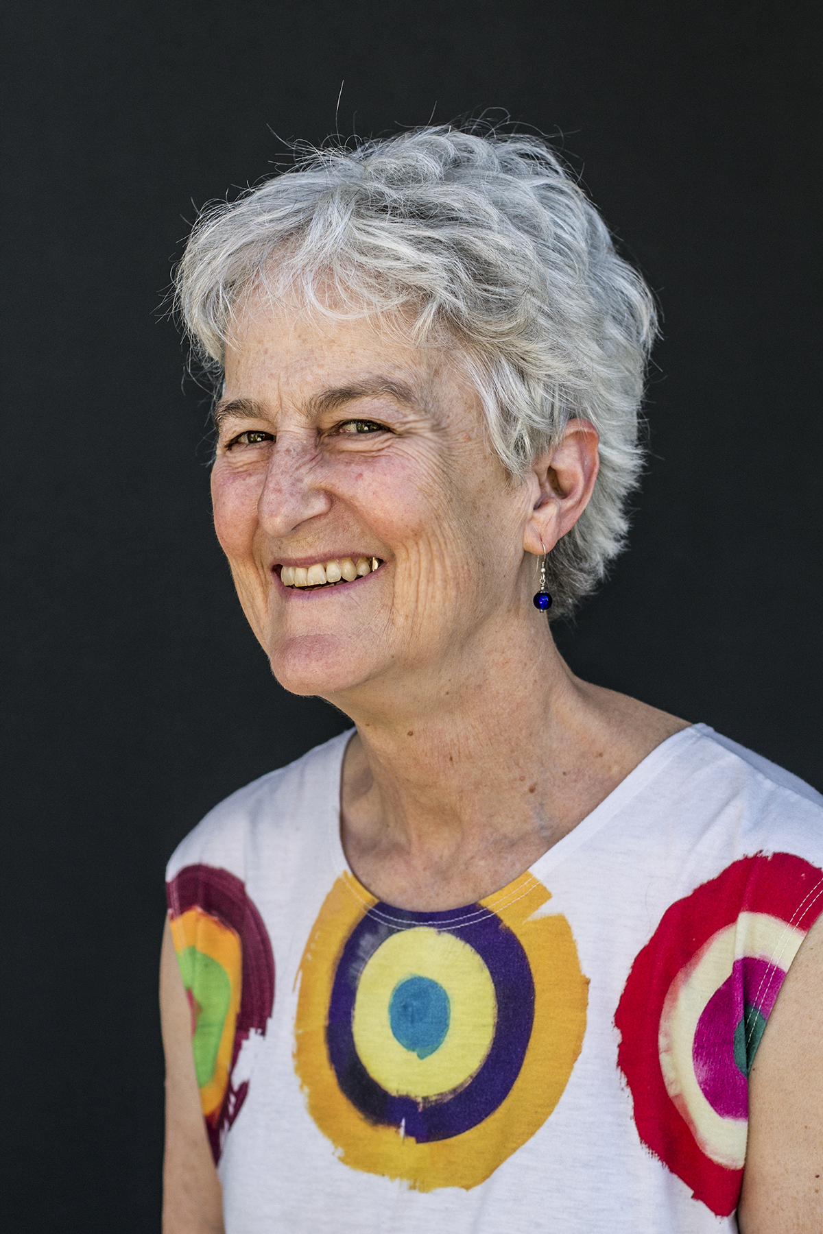 Nancy Folbre - silver haired woman smiling in a colorful top