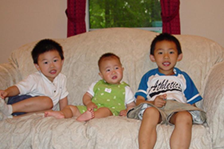 three asian boys on a couch