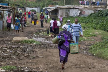 Nairobi village with a woman in purple walking.